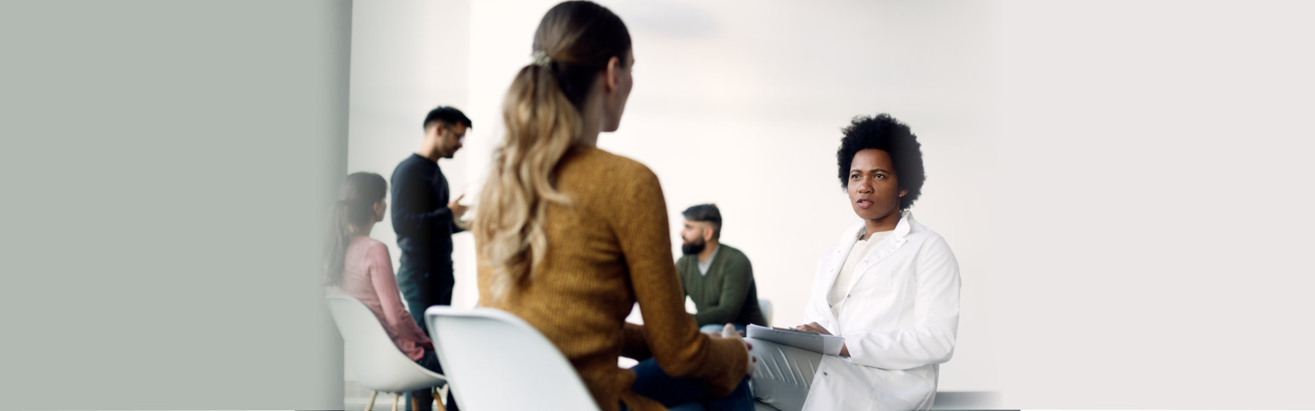 psychotherapist communicating with female patient before group session at medical center